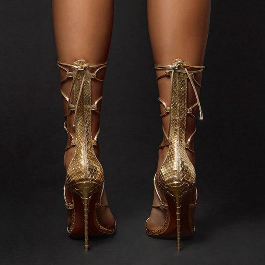 Pointed golden Roman cross strapped boots with thin heels
